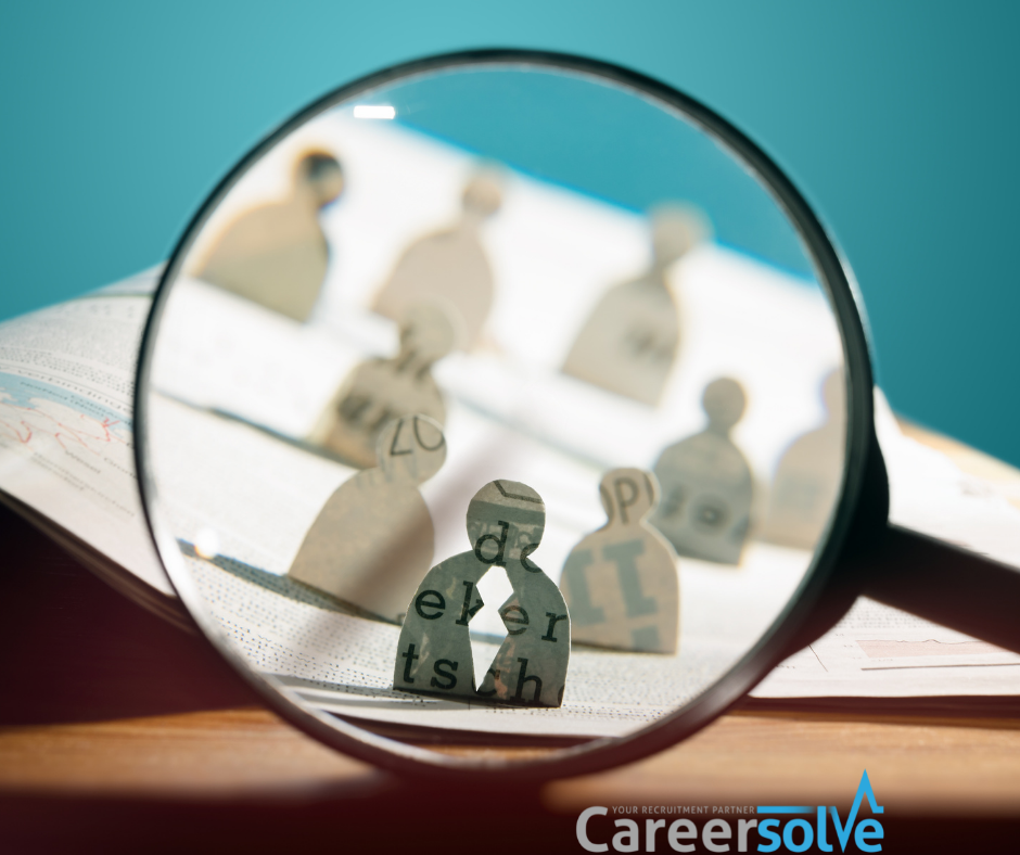 A magnifying glass representing hiring people from different backgrounds